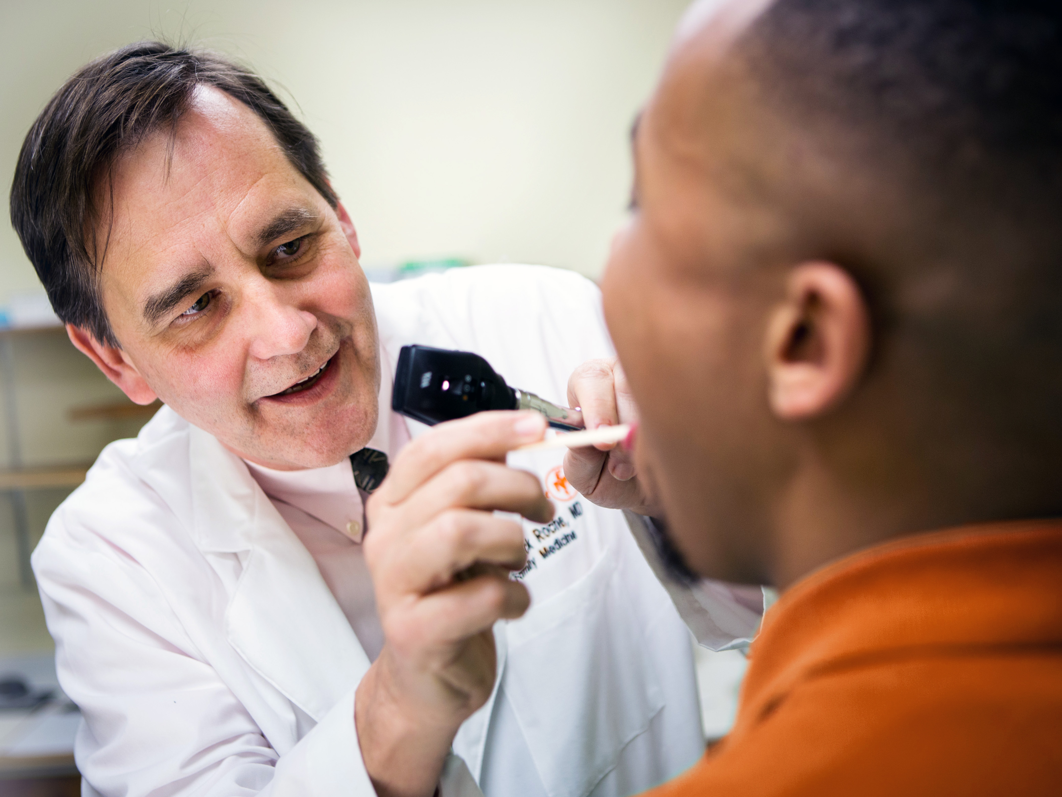 Primary care provider checking a patient’s throat in the clinic