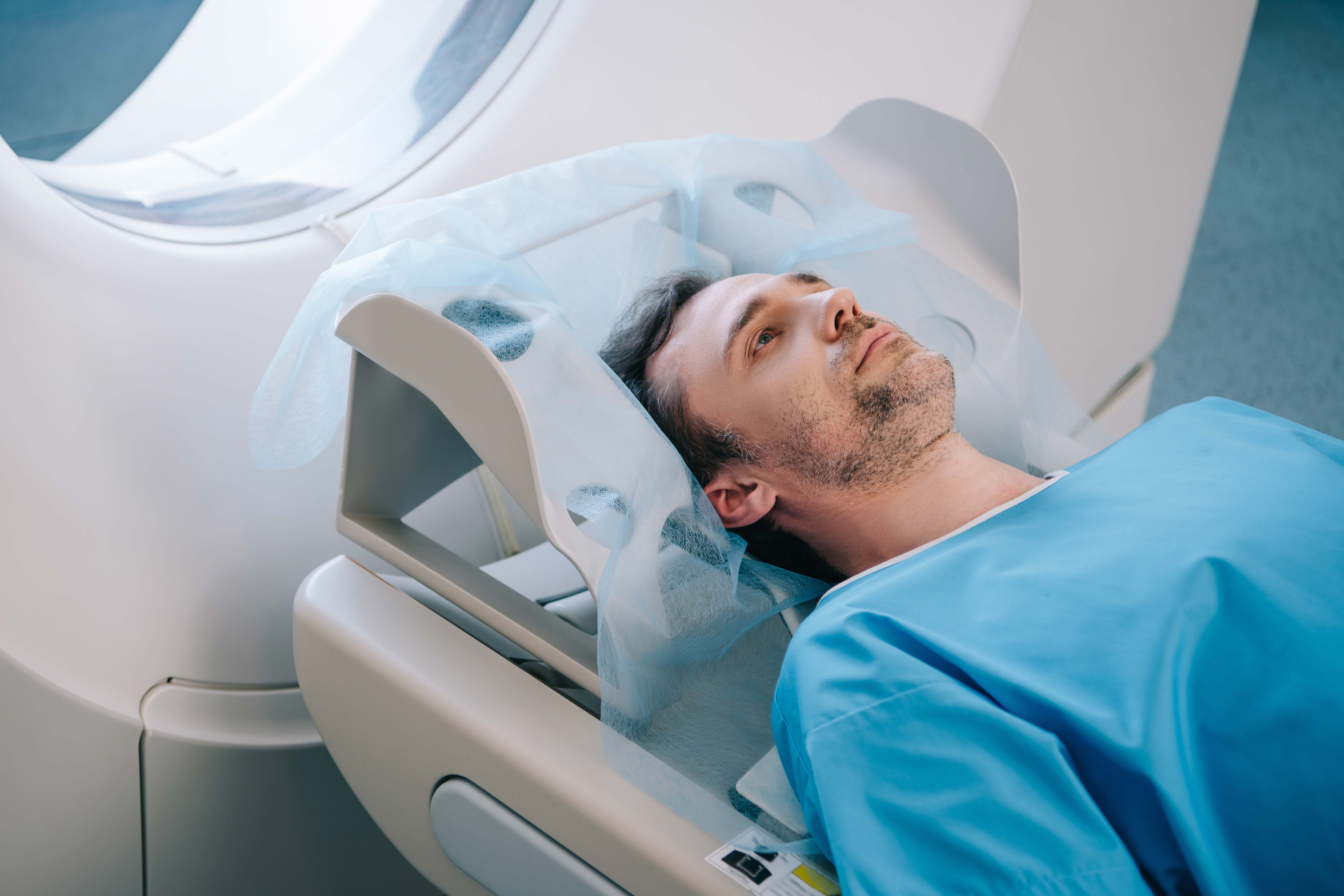 Male patient lying in a CT scanner during a heart CT calcium scan procedure.